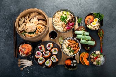 Çeşitli Çin yemekleri seti. Çin eriştesi, kızarmış pirinç, mantı, Çin yemeği, börek. Siyah arka planda ünlü Çin yemekleri. Üst görünüm. 