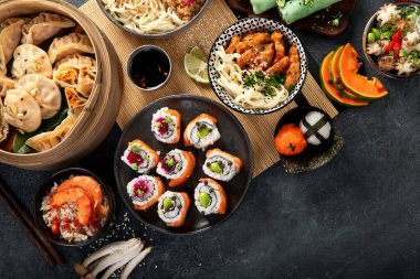 Çeşitli Çin yemekleri seti. Çin eriştesi, kızarmış pirinç, mantı, Çin yemeği, börek. Siyah arka planda ünlü Çin yemekleri. Üst Manzara. Boşluğu kopyala.