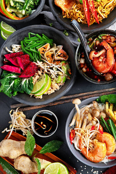 Ассорти тайской еды. Знаменитые блюда кухни на столе на темном фоне. Вид сверху. Концепция тайского ресторана.