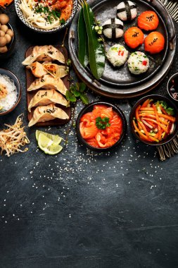 Karanlık bir arka planda suşi ve Japon yemeği. Suşi, çorba, kızarmış pirinç, nigiri, soya sosu, yemek çubukları. Asya / Japon gıda iskeleti. Üst Manzara. Boşluğu kopyala.