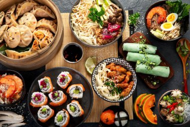 Çeşitli Çin yemekleri seti. Çin eriştesi, kızarmış pirinç, mantı, Çin yemeği, börek. Siyah arka planda ünlü Çin yemekleri. Üst görünüm. 