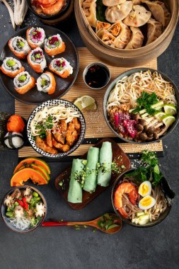 Çeşitli Çin yemekleri seti. Çin eriştesi, kızarmış pirinç, mantı, Çin yemeği, börek. Siyah arka planda ünlü Çin yemekleri. Üst Manzara. Boşluğu kopyala.