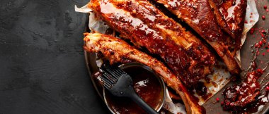 Barbekü soslu bir tabakta servis edilen sıcak ızgara pirzola. Üst Manzara. Kopyalama alanı olan Panorama.