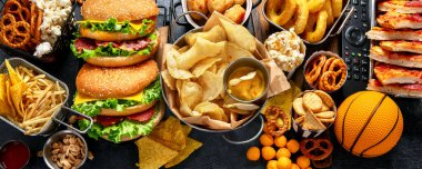 Futbol şampiyonasını karanlık bir arkaplanda izlemek için parti yemeği seçimi. Super Bowl. Kopyalama alanı olan Panorama.