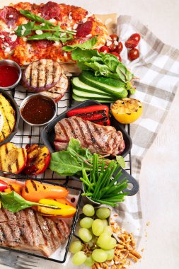Izgara ve et. Pişmiş biftek, mısır, biber, şeftali. Yemek konsepti. Üst görünüm
