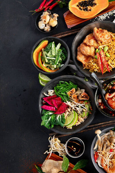 Ассорти тайской еды. Знаменитые блюда кухни на столе на темном фоне. Вид сверху. Концепция тайского ресторана. Копирование пространства.