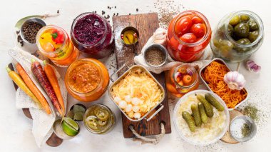 Ahşap arka planda mayalanmış ürünler. Kavanozda sebze turşusu. Üst görünüm