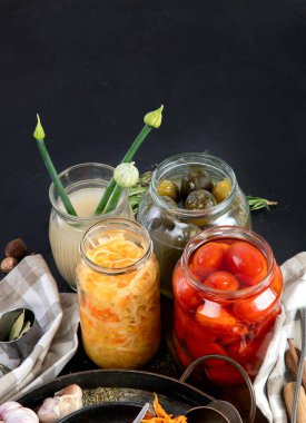 Karanlık bir arka planda mayalanmış ürünler. Kavanozda sebze turşusu. Üst görünüm, alanı kopyala