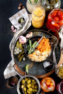 Karanlık bir arka planda mayalanmış ürünler. Kavanozda sebze turşusu. Üst görünüm