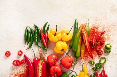 Hafif ahşap arka planda renkli çiğ biberler. Lezzetli sebze konsepti. Üst görünüm, alanı kopyala
