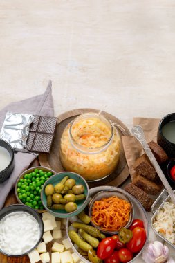 Probiotic food concept. Cabbage in jar, pickle, carrot on light wooden background. Top view, copy space clipart