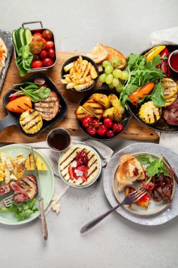 Izgara yemekli bir masa. Pizza, mısır, domates, biber, pişmiş et. Mangal zamanı. Üst görünüm