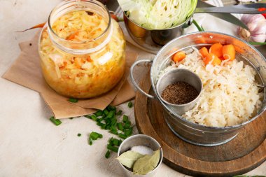 Tahta zemin üzerinde salamura edilmiş lahana salatası ve ev yapımı lahana turşusu kavanozu. Üst görünüm