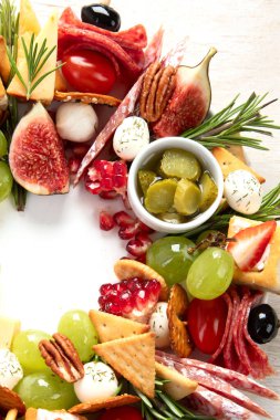 Noel için atıştırmalık çelenk. Sebzeli peynirli kanepeler ve beyaz arka planda salam. Noel çelengi. Üst görünüm.