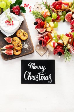 Peynir ve meze çeşitleri. Hafif bir arka planda Noel çelengi. Üst Manzara. Boşluğu kopyala.