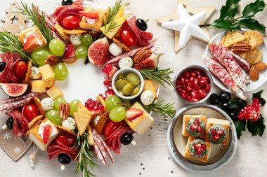 Peynir ve meze çeşitleri. Hafif bir arka planda Noel çelengi. Üst görünüm.