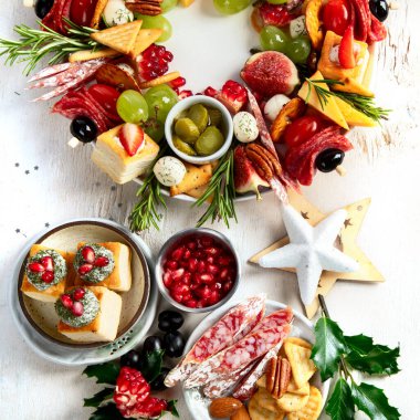 Peynir ve meze çeşitleri. Hafif bir arka planda Noel çelengi. Üst görünüm.