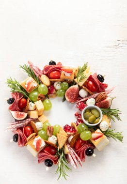 Noel için atıştırmalık çelenk. Sebzeli peynirli kanepeler ve beyaz arka planda salam. Noel çelengi. Üst Manzara. Boşluğu kopyala.