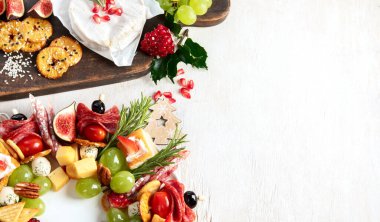 Peynir ve meze çeşitleri. Hafif bir arka planda Noel çelengi. Üst Manzara. Kopyalama alanı olan Panorama.