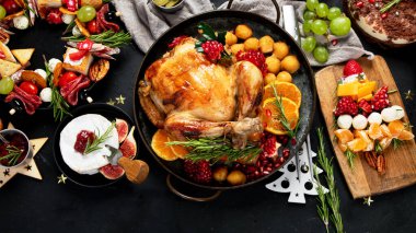 Kızarmış tavuk, Noel çelengi, ağaç, pasta, atıştırmalık, peynir ve şampanyayla dolu bir Noel yemeği. Üst Manzara. Kopyalama alanı olan Panorama
