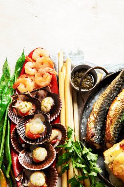 Çeşitli Akdeniz yemekleri - balık, karides, deniz ürünleri, ravioli, beyaz arka planda sebzeler. Üst Manzara. Boşluğu kopyala.