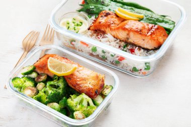 Hafif bir arka planda yemek hazırlamak için yapılmış cam kaplarda pirinç ve sebzeli somon balığı. Sağlıklı yaşam tarzı.