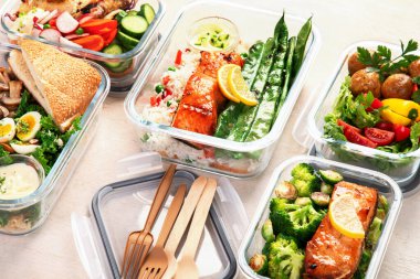 Beyaz arka plandaki konteynırlarda farklı lezzetli sağlıklı yemekler.. 