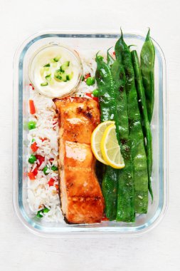 Hafif bir arka planda yemek hazırlamak için yapılmış cam kaplarda pirinç ve sebzeli somon balığı. Sağlıklı yaşam tarzı.