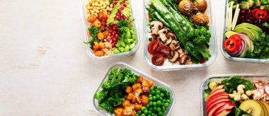 Vejetaryenler için sağlıklı yemekler hazırlıyorum. Hafif bir arka planda konteynırlarda yiyecek ve atıştırmalıklar. Üst Manzara. Kopyalama alanı olan Panorama.