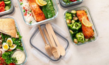 Beyaz arka plandaki konteynırlarda farklı lezzetli sağlıklı yemekler.. 