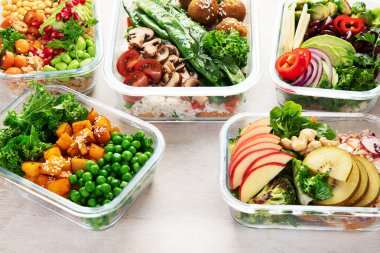 Vejetaryenler için sağlıklı yemekler hazırlıyorum. Hafif bir arka planda konteynırlarda yiyecek ve atıştırmalıklar. Üst görünüm.