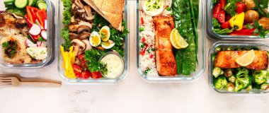 Beyaz arka planda, konteynırlarda farklı sağlıklı yemekler. Kopyalama alanı olan Panorama.