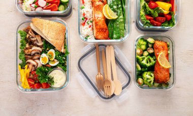 Beyaz arka planda, konteynırlarda farklı sağlıklı yemekler. Boşluğu kopyala.