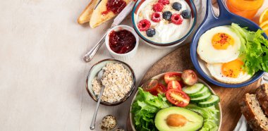 Kahvaltı masası. Portakal suyu, meyve, sebze, müsli, somon balığı, yumurta ve kruvasanın olduğu masaya yayılmış sağlıklı bir kahvaltı. Üst Manzara. Kopyalama alanı olan Panorama.