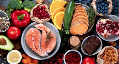 Koyu gri arka planda yaşlanma karşıtı menü. Yüksek miktarda antioksidan, mineral ve vitamin. Üst manzara, düz uzanma