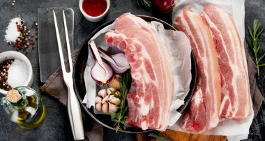 Koyu gri arka planda çiğ domuz göbeği. Organik gurme yemek konsepti. Üst görünüm, düz görünüm, kopyalama alanı