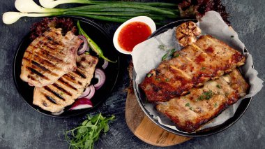 Koyu gri arka planda sebzeli ızgara domuz eti. Organik gurme yemek konsepti. Üst manzara, düz uzanma