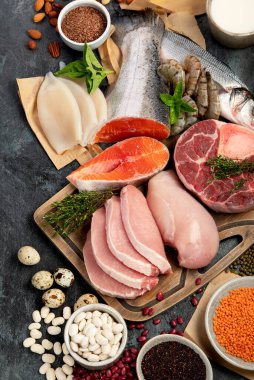 Koyu arkaplanda doğal protein kaynakları. Sağlıklı dengeli diyet kavramı. Üst görünüm, düz görünüm, kopyalama alanı