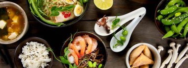 Ahşap arka planda Asya yemekleri ve atıştırmalıklar. Geleneksel gıda konsepti. Düz konum, üst görünüm, kopyalama alanı