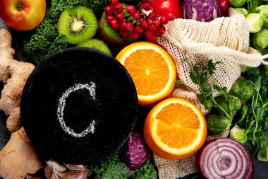 Koyu arka planda C vitamini içeren yiyecekler. Sağlıklı beslenme konsepti. Üst görünüm, düz görünüm, kopyalama alanı