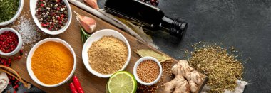 Gri arka planda çeşitli baharatlar. Geleneksel baharat konsepti. Üst görünüm, panorama, kopyalama alanı