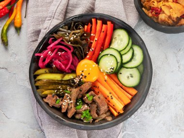 Gri arka planda aperatifleri olan bir bibimbap. Geleneksel Kore yemekleri. Üst görünüm, düz görünüm, kopyalama alanı, panorama