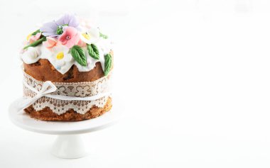 Paskalya pastası, tavşan kulaklarıyla süslenmiş tatlı ekmek ve pembe arka planda bahar çiçekleri. Üst Manzara. Boşluğu kopyala.