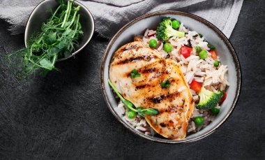 Sebzeli ızgara tavuk ve gri arka planda pilav. Sağlıklı beslenme konsepti. Üst görünüm, düz görünüm, kopyalama alanı