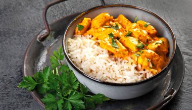 Hint tereyağlı körili tavuk ve koyu arkaplanda basmati pilavı. Geleneksel ev yapımı yemek konsepti. Boşluğu kopyala