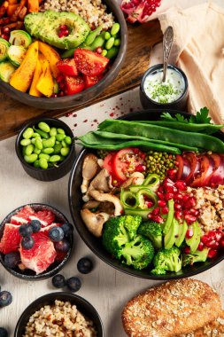 Buda, arka planda vejetaryenler için karışık sebze kaseleri hazırlar. Sağlıklı beslenme konsepti. Üst görünüm.