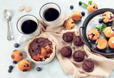 Hafif arka planda muffinler. Taze pişmiş kekler. Kutlama konsepti. Üst manzara, düz uzanma