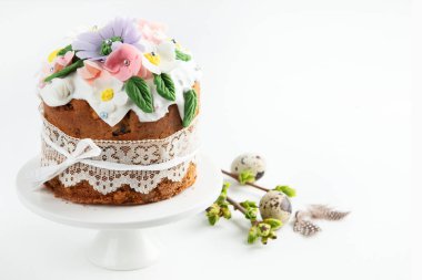 Paskalya pastası, tavşan kulaklarıyla süslenmiş tatlı ekmek ve pembe arka planda bahar çiçekleri. Üst görünüm.