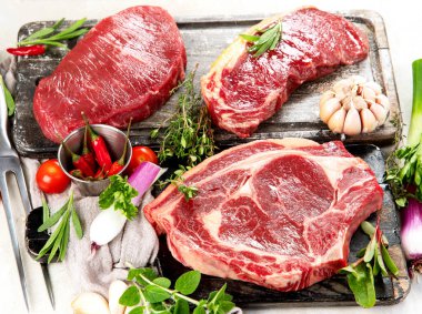 Baharatlı ve otlu lezzetli biftekler yapmak için taze çiğ et. Izgara et için hazırlık 