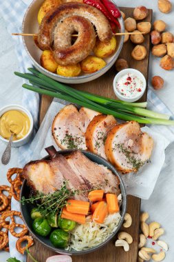 Geleneksel Alman mutfağı, Schweinshaxe kızarmış jambon. Bira, kraker ve tahtadan yapılmış çeşitli Bavyera atıştırmalıkları, beyaz arka plan, üst manzara.